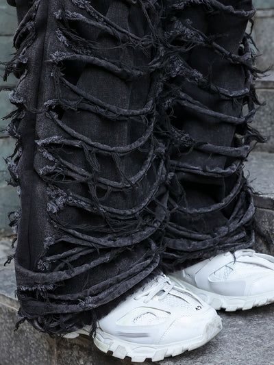 Men's black jeans. With a design of (ripped holes) and tassels. In a street trend style.