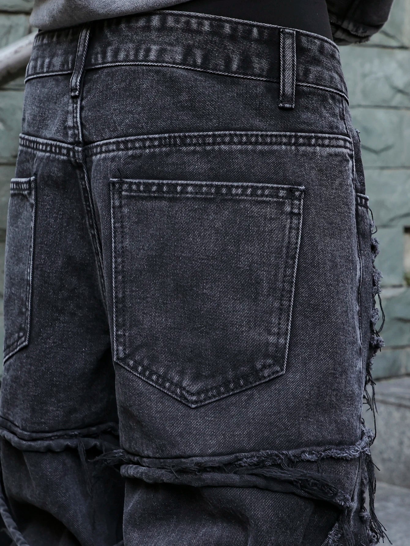 Men's black jeans. With a design of (ripped holes) and tassels. In a street trend style.